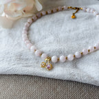 Detailaufnahme der Cherry Love Rosenquarz-Kette mit vergoldetem Kirsch-Anhänger und funkelnden Zirkonia