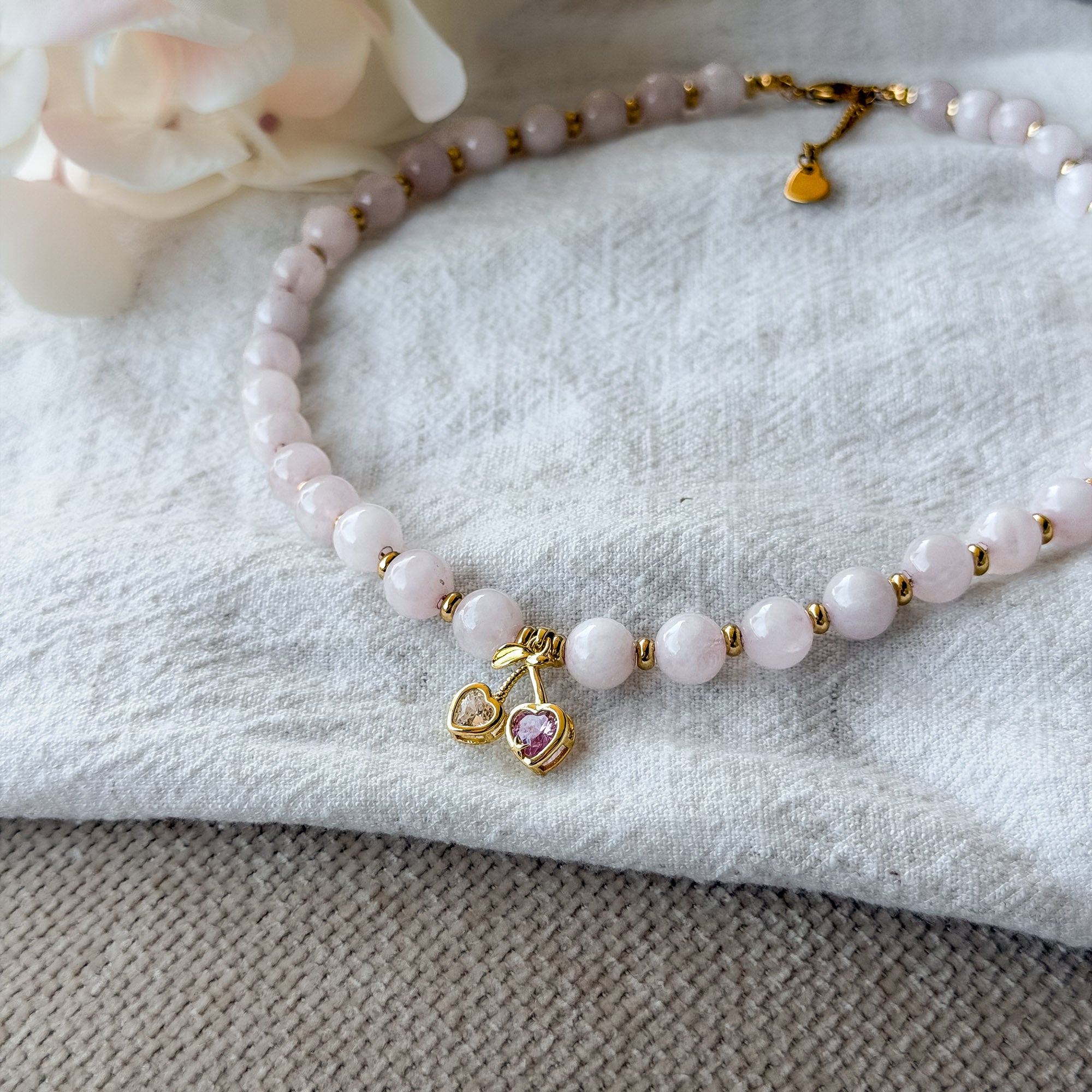 Detailaufnahme der Cherry Love Rosenquarz-Kette mit vergoldetem Kirsch-Anhänger und funkelnden Zirkonia