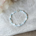 Handgefertigtes Noa Kreuz-Armband aus weißen Muschelkreuzen und hellblauen Miyuki-Perlen