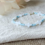 Detailaufnahme des Noa Armbands mit weißen Muschelkreuzen und hellblauen Miyuki-Perlen