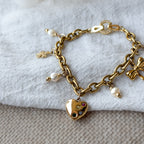 Detailaufnahme des Amelie Bettelarmbands mit Herz-Charm, Süßwasserperlen und 18k vergoldeter Edelstahlkette