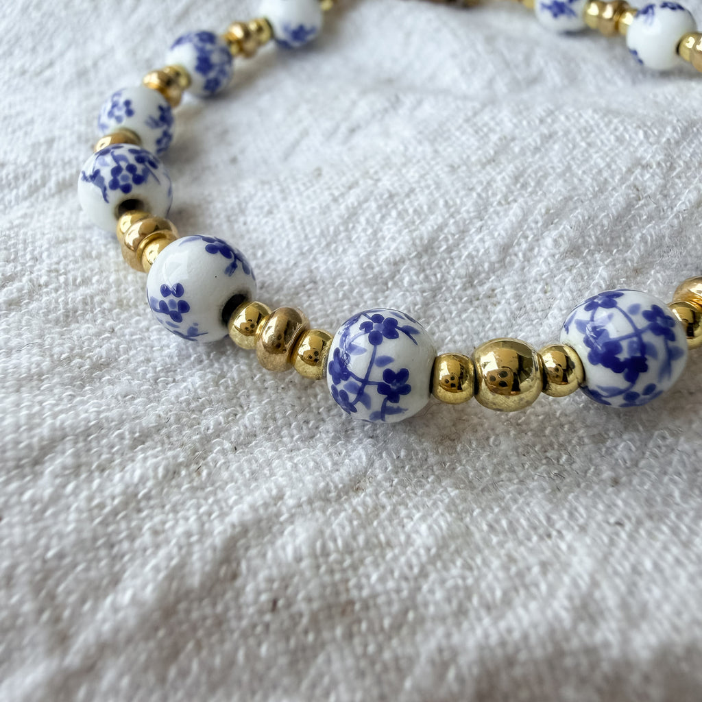 Detailaufnahme der blau-weißen Porzellanperlen und goldbeschichteten Perlen des Marisol Armbands