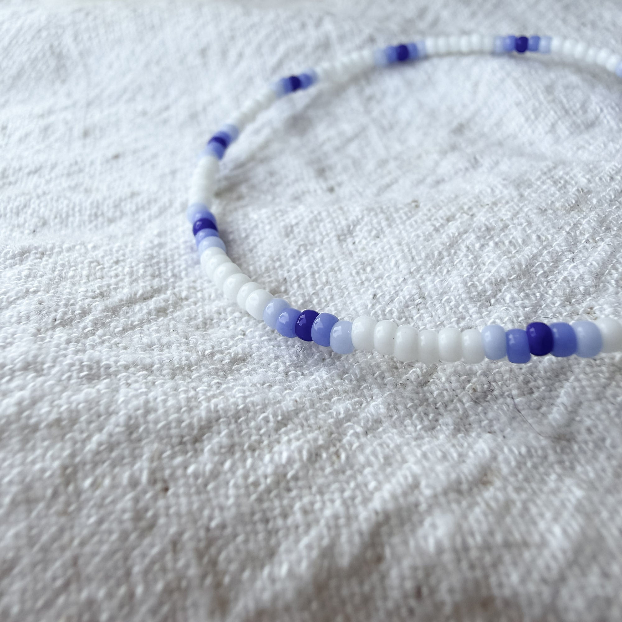 Detailaufnahme des Lina Armbands aus weißen und blauen Miyuki-Perlen