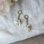 Romantische Edelstahl-Ohrringe mit Perlmutt-Blüten und vergoldeten Huggie-Creolen – leicht und elegant.