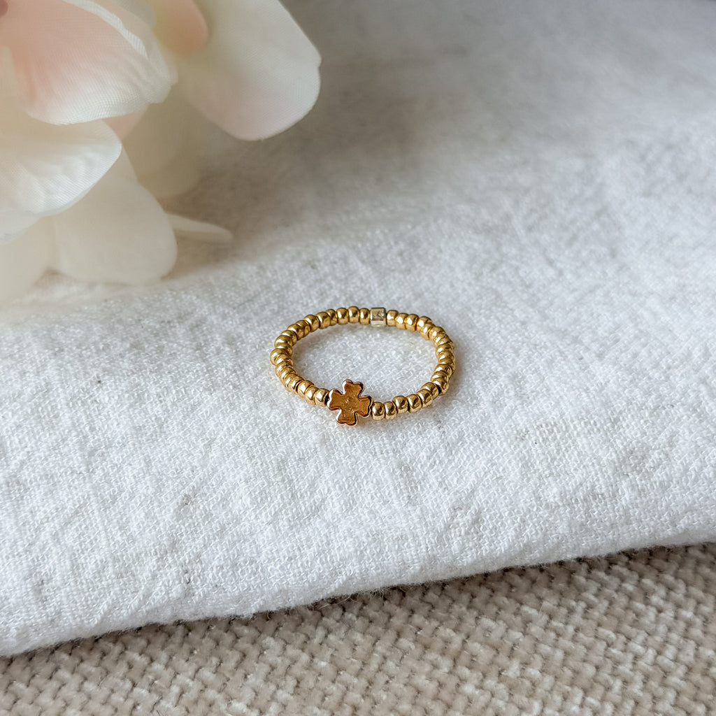 Handgefertigter elastischer Perlenring aus goldfarbenen Miyuki-Perlen und Kleeblatt