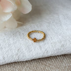Handgefertigter elastischer Perlenring aus goldfarbenen Miyuki-Perlen und Kleeblatt