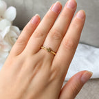 Elastischer Felicia Miyuki-Ring mit goldenem Kleeblatt am Finger getragen